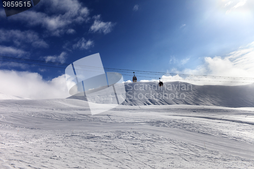 Image of Gondola lift and ski slope at sun day