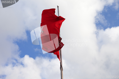 Image of Turkish flag on flagpole waving in wind