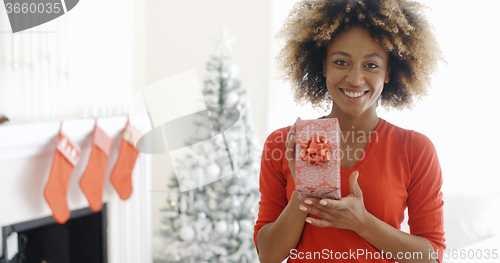 Image of Smiling African woman holding a Christmas gift