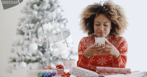 Image of Young African woman checking for Xmas messages