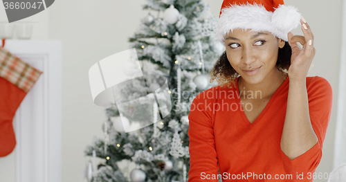 Image of Happy festive young woman in a Santa hat