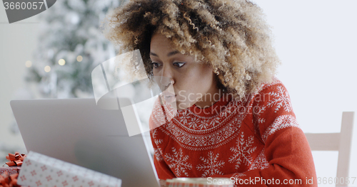 Image of Excited woman shopping online for Xmas bargains