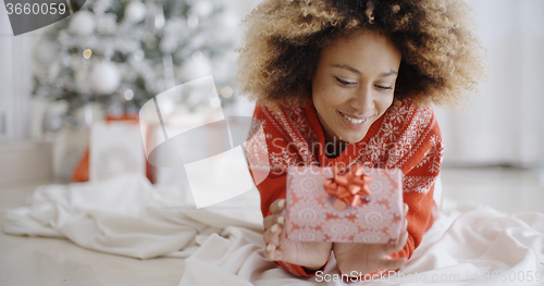 Image of Thoughtful young woman with a Christmas gift