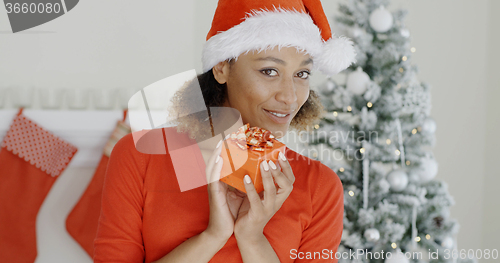 Image of Pretty woman in Santa hat holding a gift