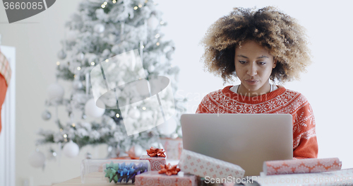 Image of Young woman using a laptop at Christmas