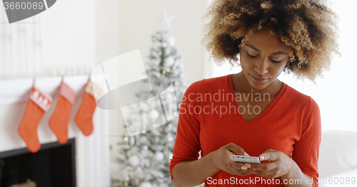 Image of Young woman checking her Christmas messages