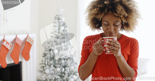 Image of Pretty young African woman enjoying coffee