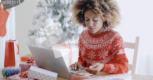 Image of Young woman doing Xmas shopping online