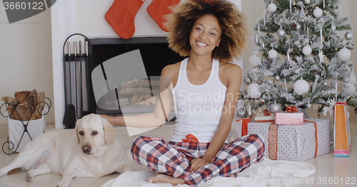 Image of Young woman celebrating Christmas with her dog