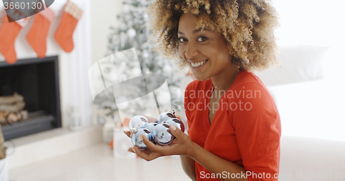 Image of Young woman carrying a handful of Xmas decorations