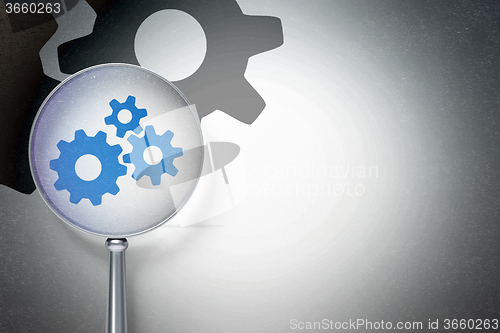 Image of Advertising concept:  Gears with optical glass on digital background