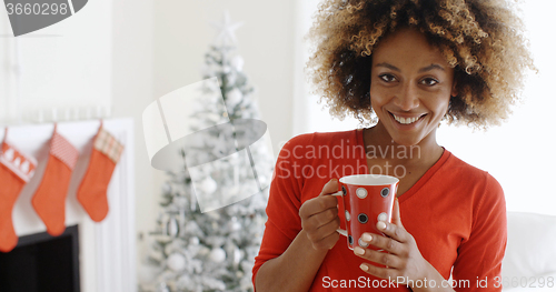 Image of Pretty young African woman enjoying coffee