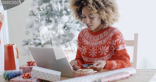 Image of Young woman doing Xmas shopping online