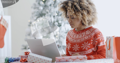 Image of Trendy young woman working on a laptop