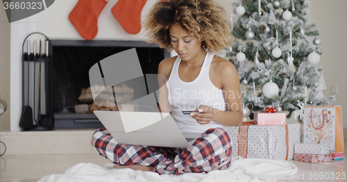 Image of Young woman shopping online for Christmas