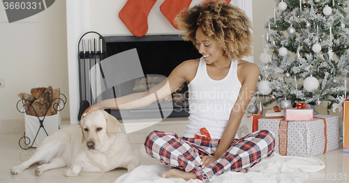 Image of Young woman celebrating Christmas with her dog