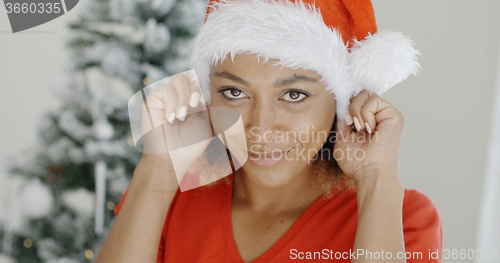 Image of Attractive young woman donning a Santa hat