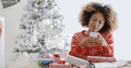 Image of Young African woman checking for Xmas messages