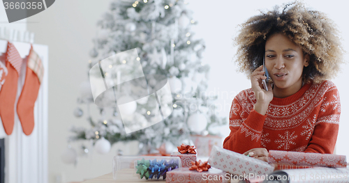 Image of Young African woman wrapping gifts at Christmas