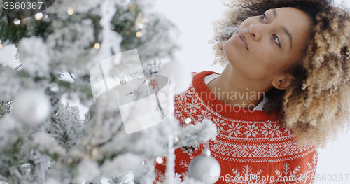 Image of Pretty young woman decorating a Christmas tree