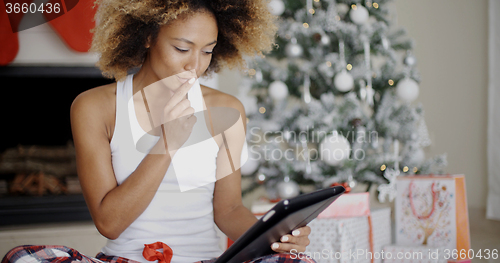 Image of Thoughtful woman catching up on Christmas news