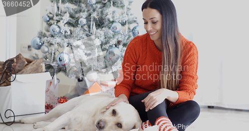 Image of Laughing young woman with her dog at Christmas