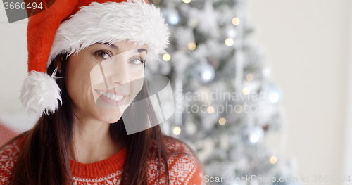 Image of Smiling gorgeous young woman in a Santa hat