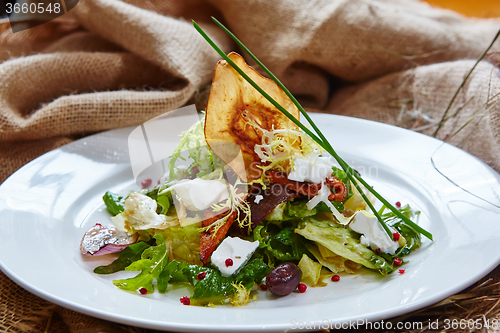 Image of Fresh spring salad with feta cheese, red onion in white bowl. 