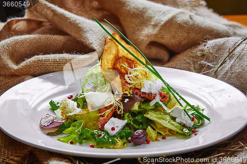 Image of Fresh spring salad with feta cheese, red onion in white bowl. 