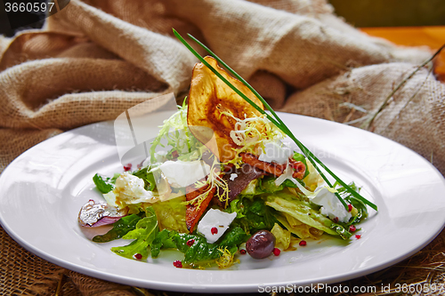 Image of Fresh spring salad with feta cheese, red onion in white bowl. 