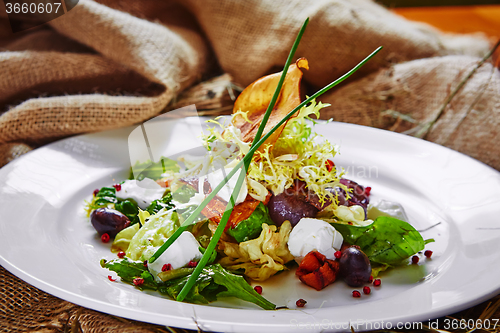 Image of Fresh spring salad with feta cheese, red onion in white bowl. 