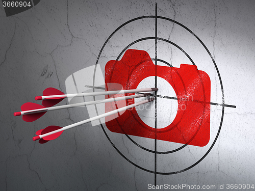 Image of Vacation concept: arrows in Photo Camera target on wall background