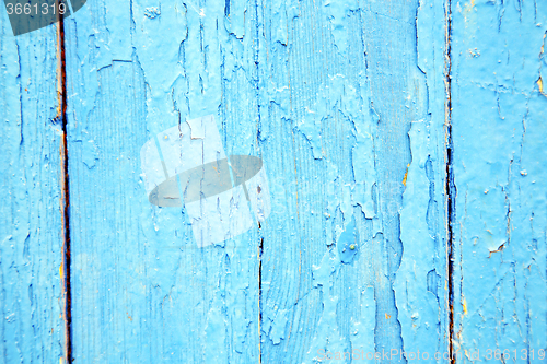 Image of dirty stripped paint in the blue wood door and  