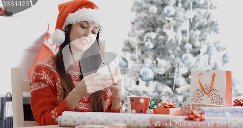 Image of Attractive woman checking for Christmas messages