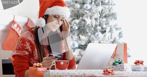 Image of Young woman ordering Christmas gifts online