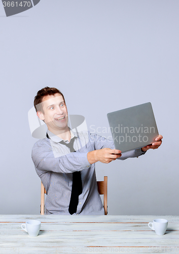 Image of Happy man working on laptop in the office