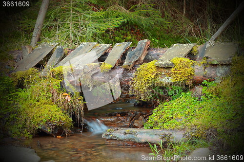 Image of wooden old bridge on mountain stream