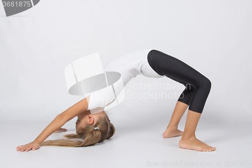 Image of An aspiring gymnast attempts to perform an exercise bridge