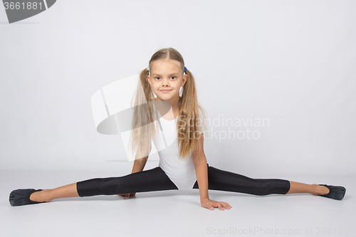 Image of Girl gymnast almost sat down on the twine