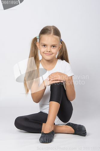 Image of Girl gymnast sitting on the floor
