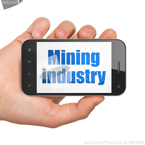 Image of Industry concept: Hand Holding Smartphone with Mining Industry on display