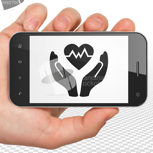 Image of Insurance concept: Hand Holding Smartphone with Heart And Palm on display