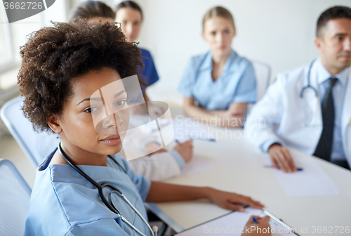 Image of female doctor over group of medics at hospital