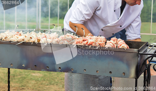 Image of People at work: a man grilling shashlik on the grill.