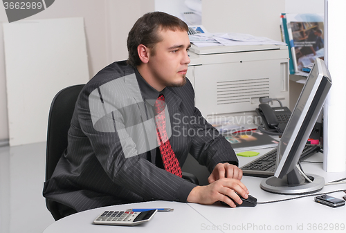 Image of Businessman in office working with PC