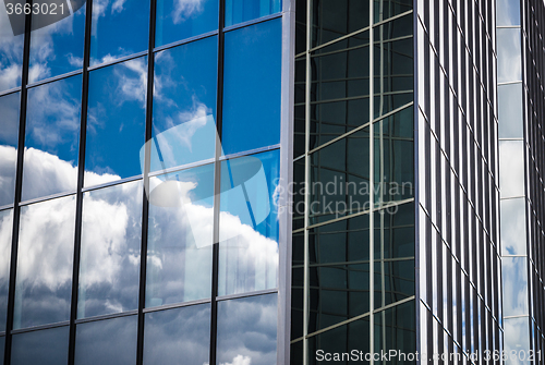 Image of Glass facade of an office building with reflection of the sky, c