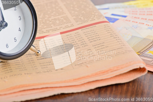 Image of Close-up of clock, Euro banknotes and newspaper