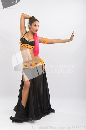 Image of Young girl mulatto dancing in a long black dress candid