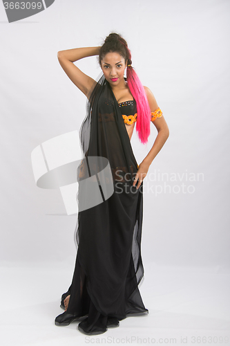 Image of Young girl mulatto dancing in a long black dress candid