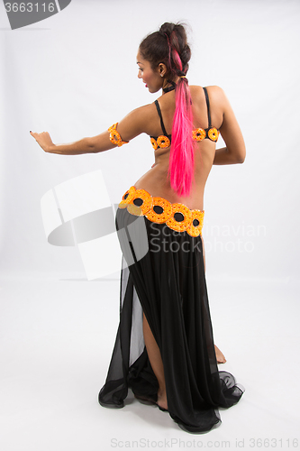 Image of Young girl mulatto dancing in a long black dress candid